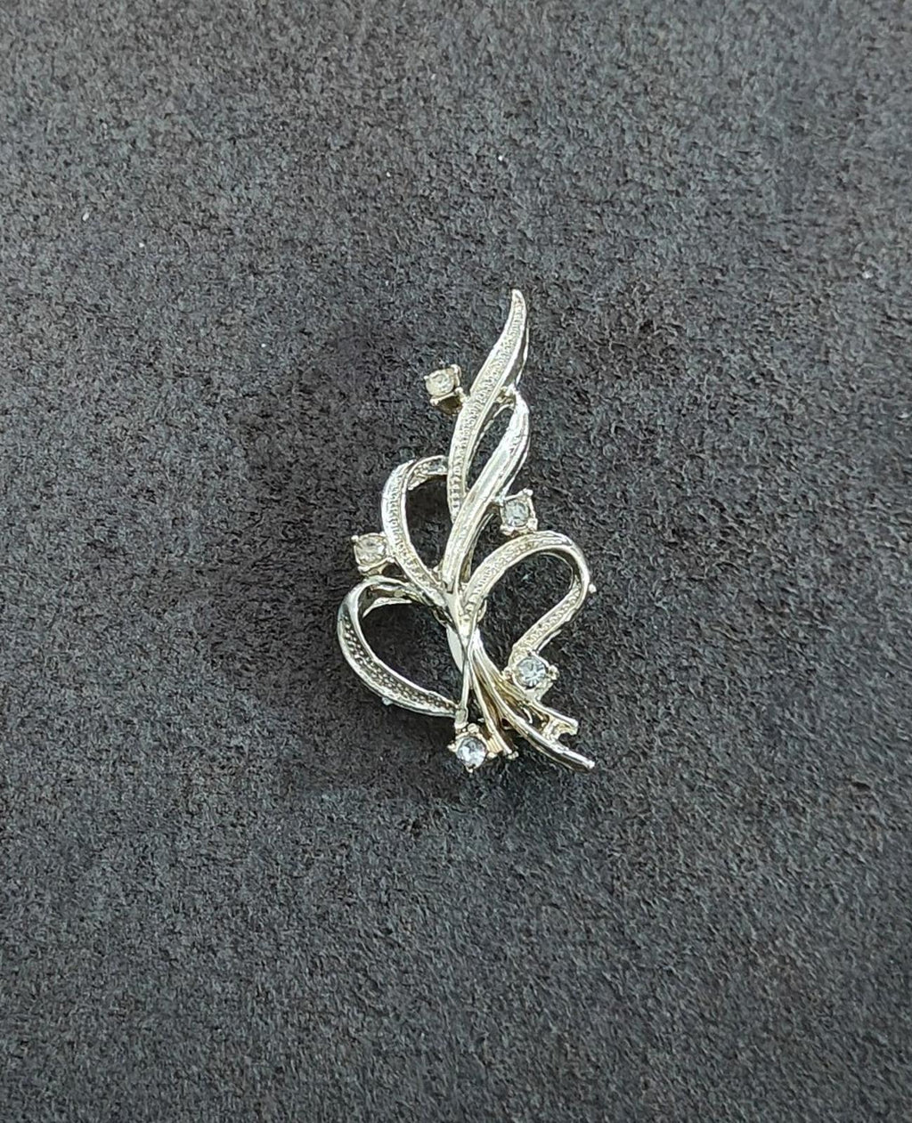 Gold-tone ribbon brooch pin with curved vine design and tiny rhinestones