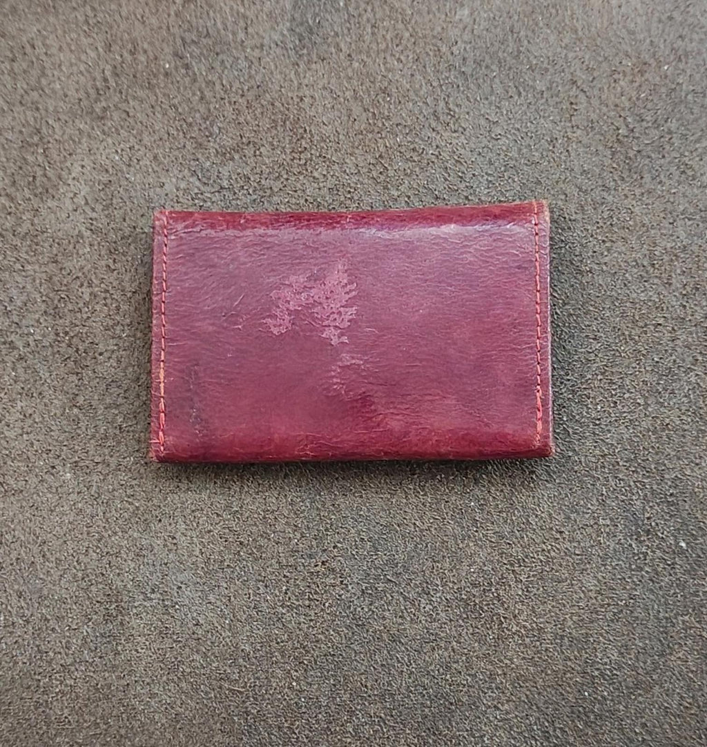 Rectangular burgundy coin purse wallet with distressed leather texture and stitched edges.
