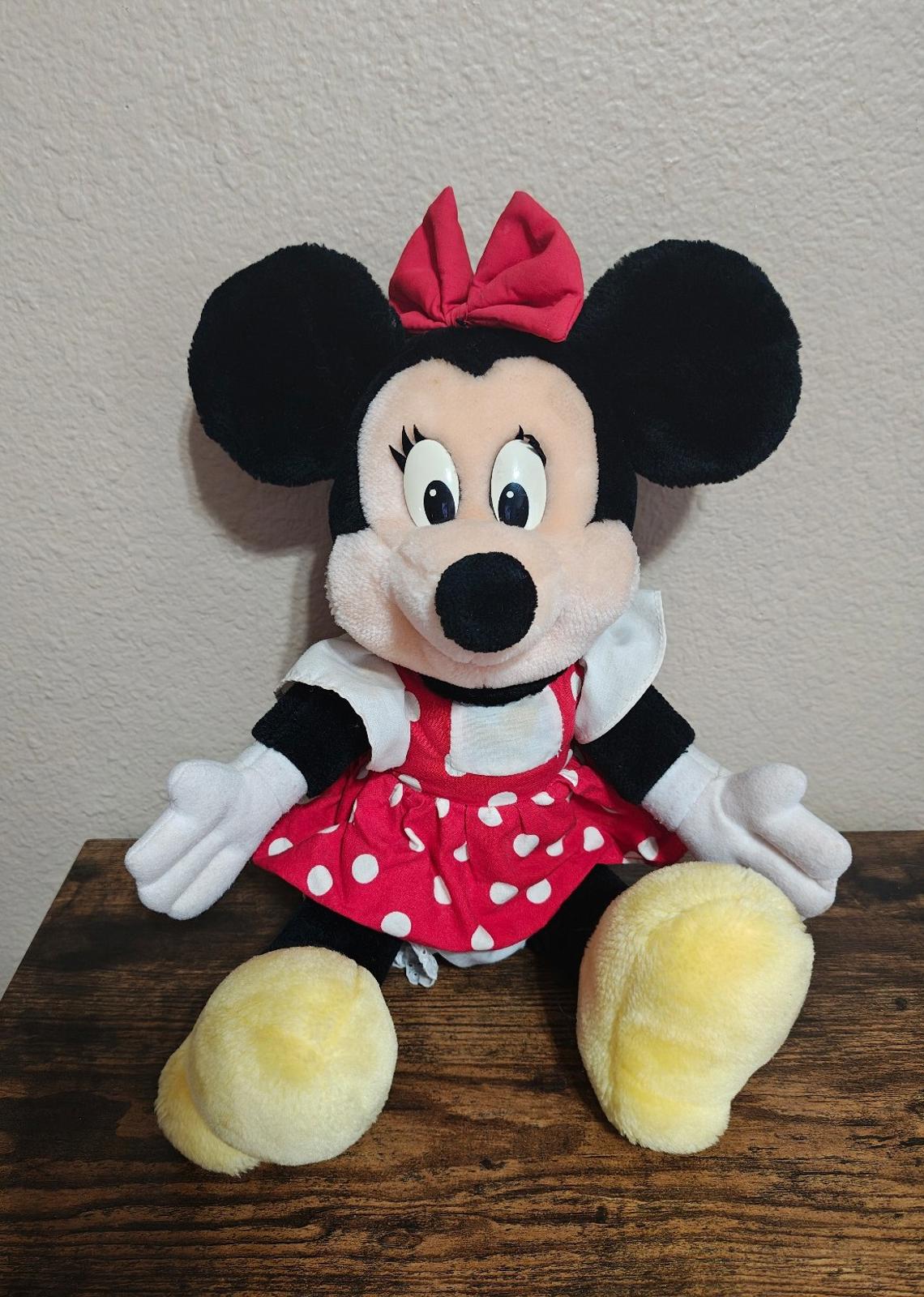 Minnie Mouse plush sitting with red bow and red polka-dot dress, white collar and gloves