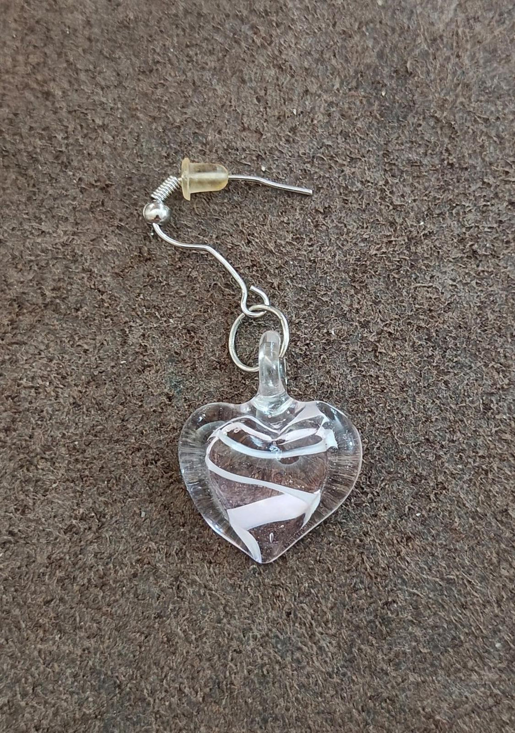 Heart-shaped glass dangle earring with swirl detail and silver-tone hook.