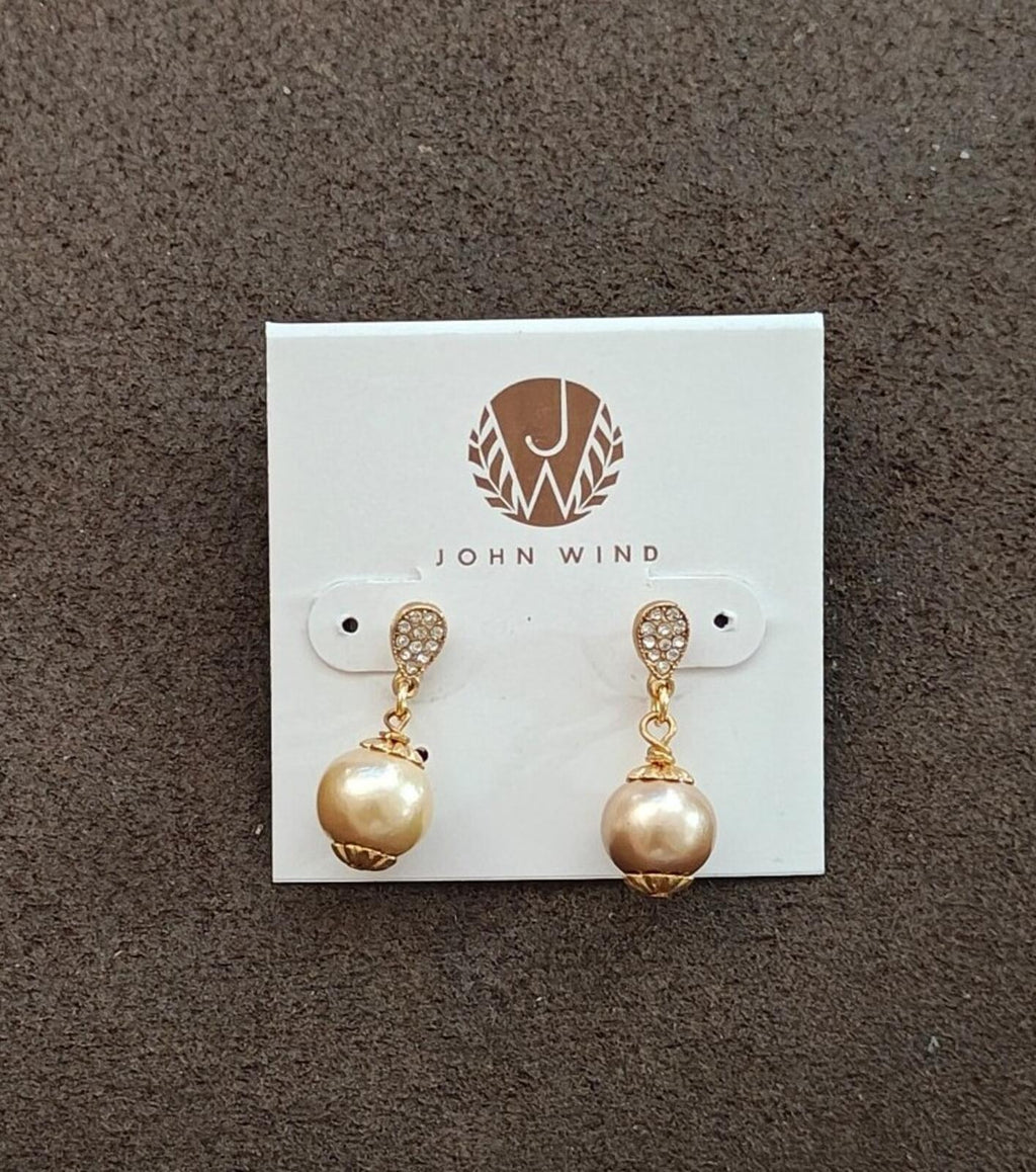 Gold tone dangle earrings with round pearl-like beads and rhinestone-studded caps