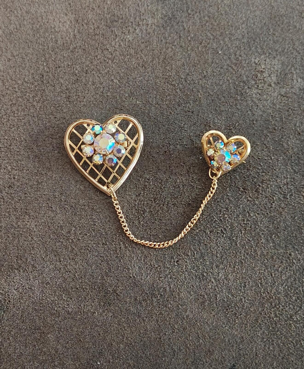Gold-tone double heart brooch with blue iridescent rhinestones and linked chain connector