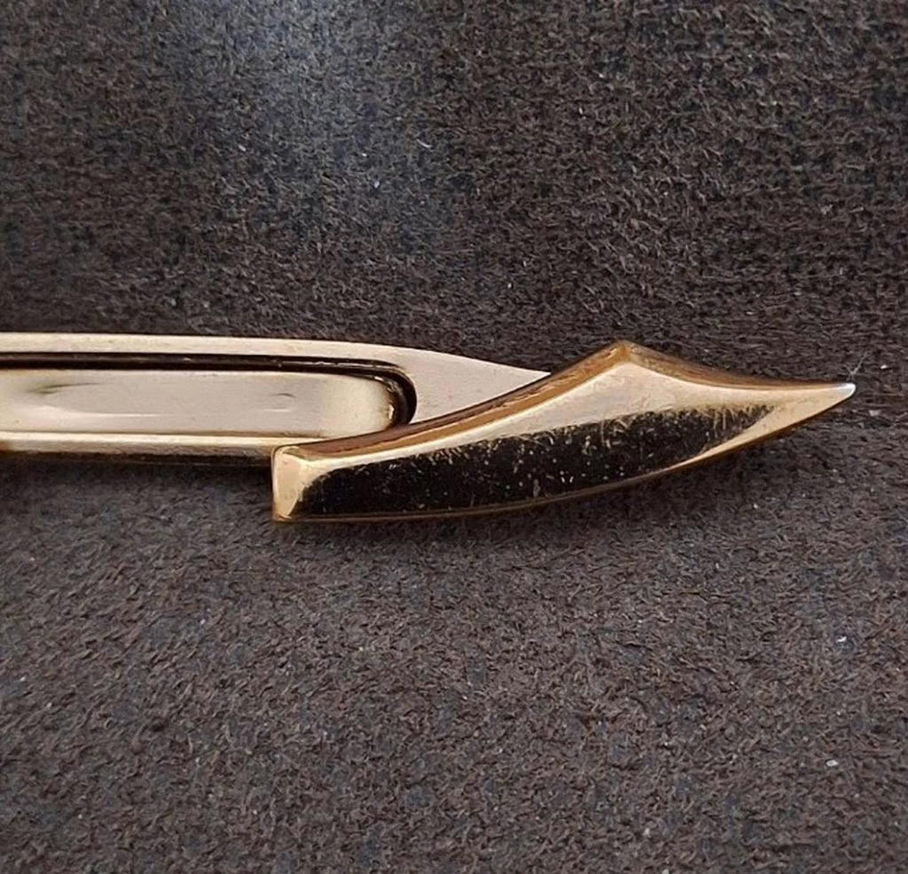 Gold pirate sword tie clip bar close-up of pointed blade end