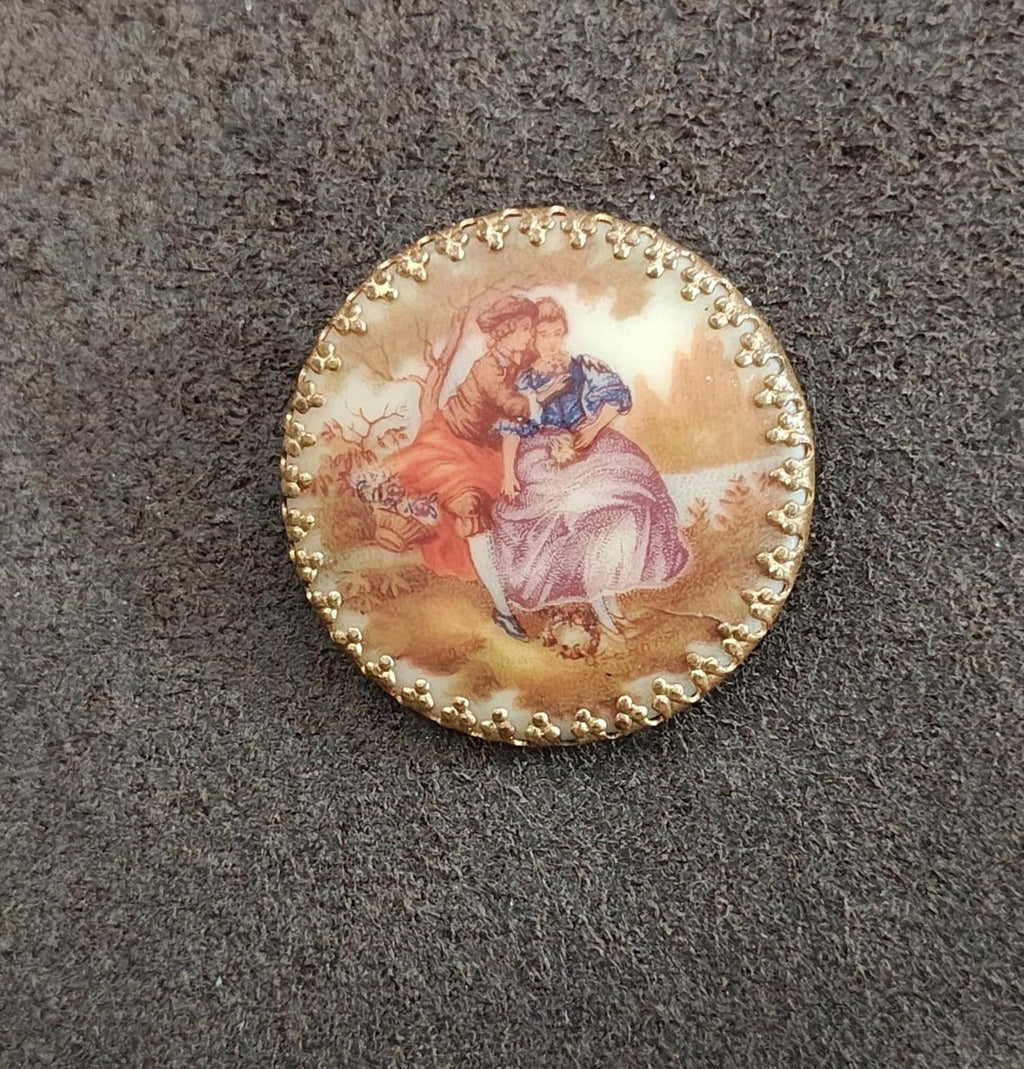 Gold oval porcelain cameo brooch showing romantic courting scene with beaded rim
