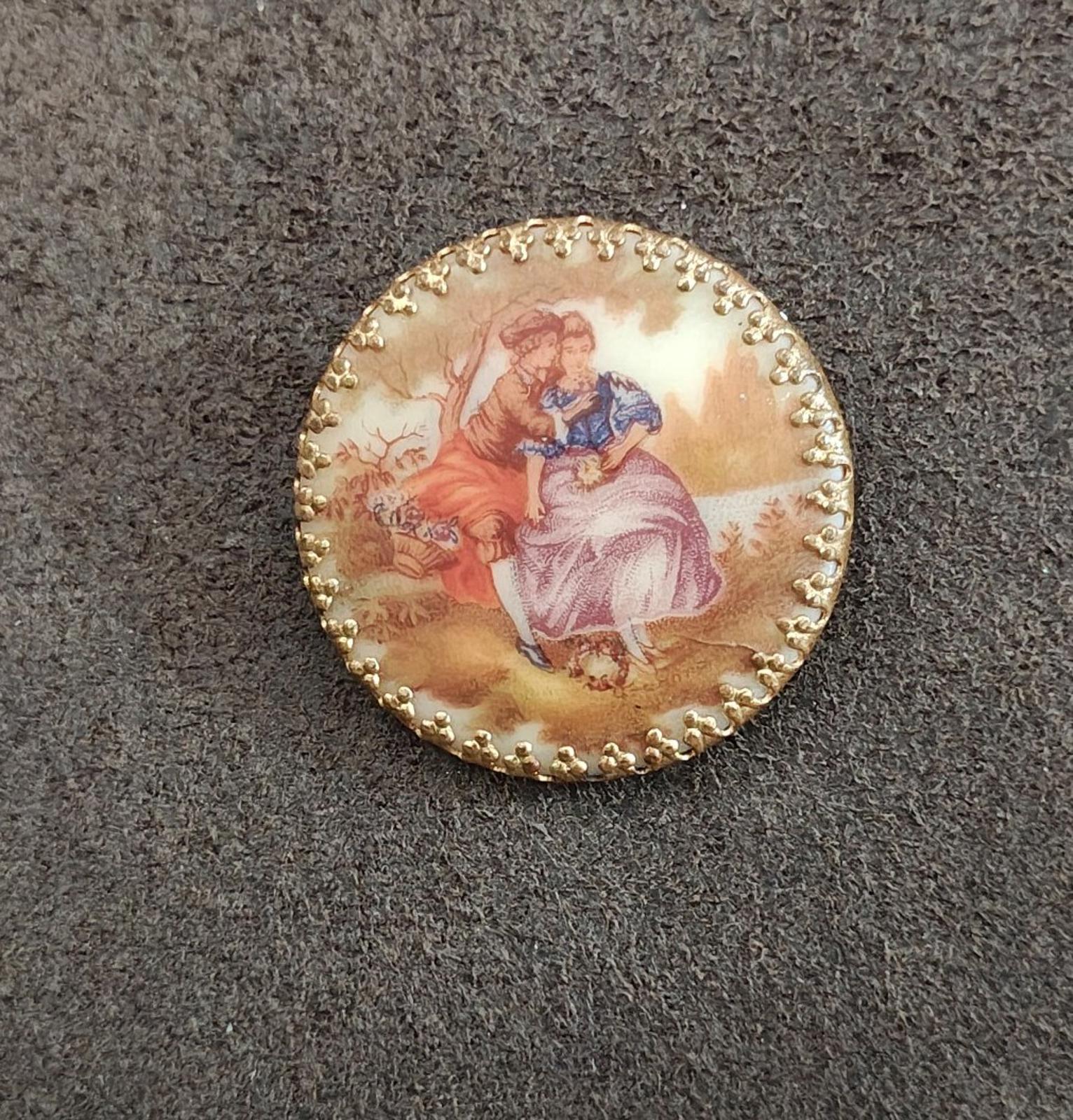 Gold oval porcelain cameo brooch showing romantic courting scene with beaded rim