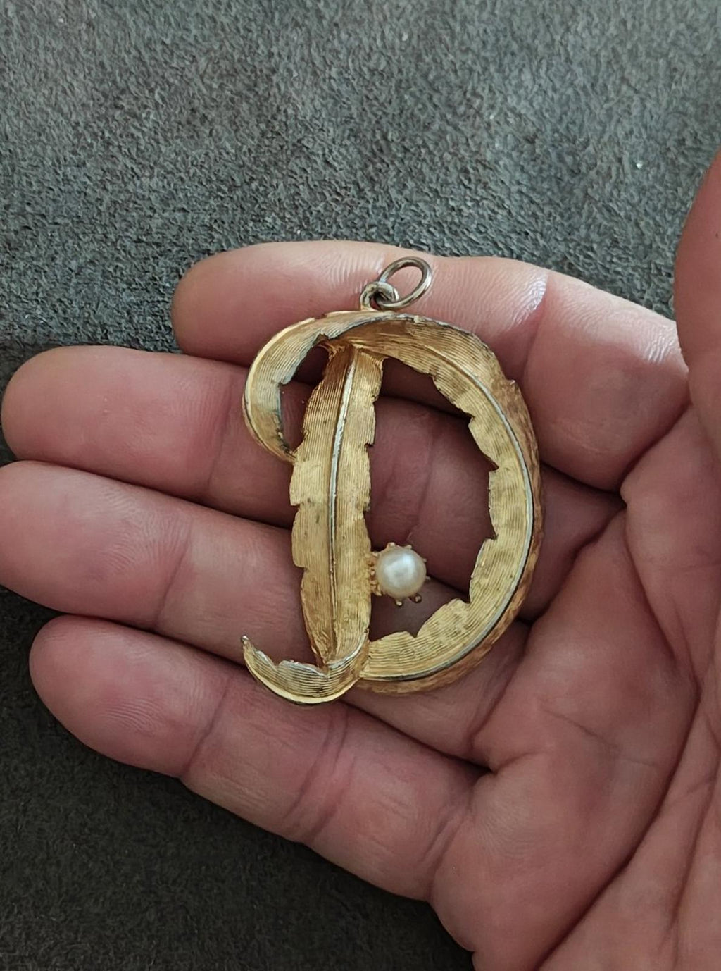Gold-tone letter D monogram pendant with pearl accent on ornate openwork frame