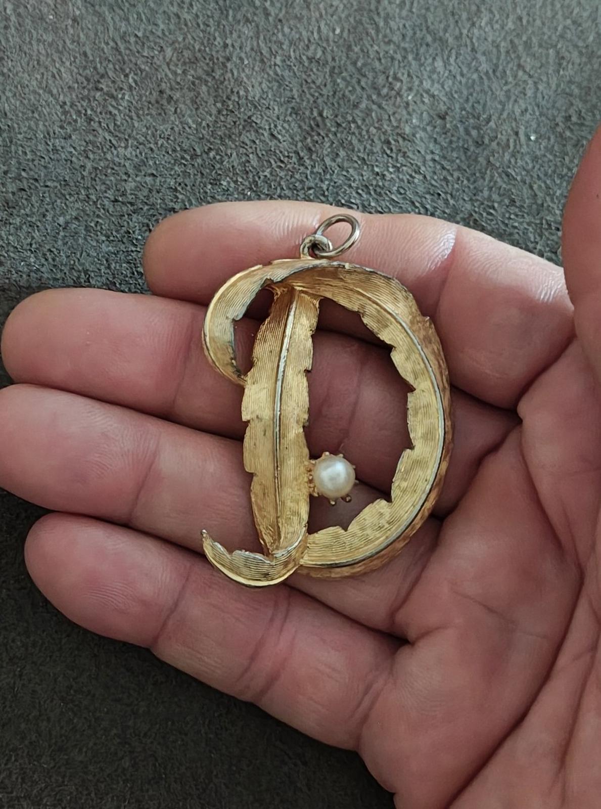 Gold-tone letter D monogram pendant with pearl accent on ornate openwork frame