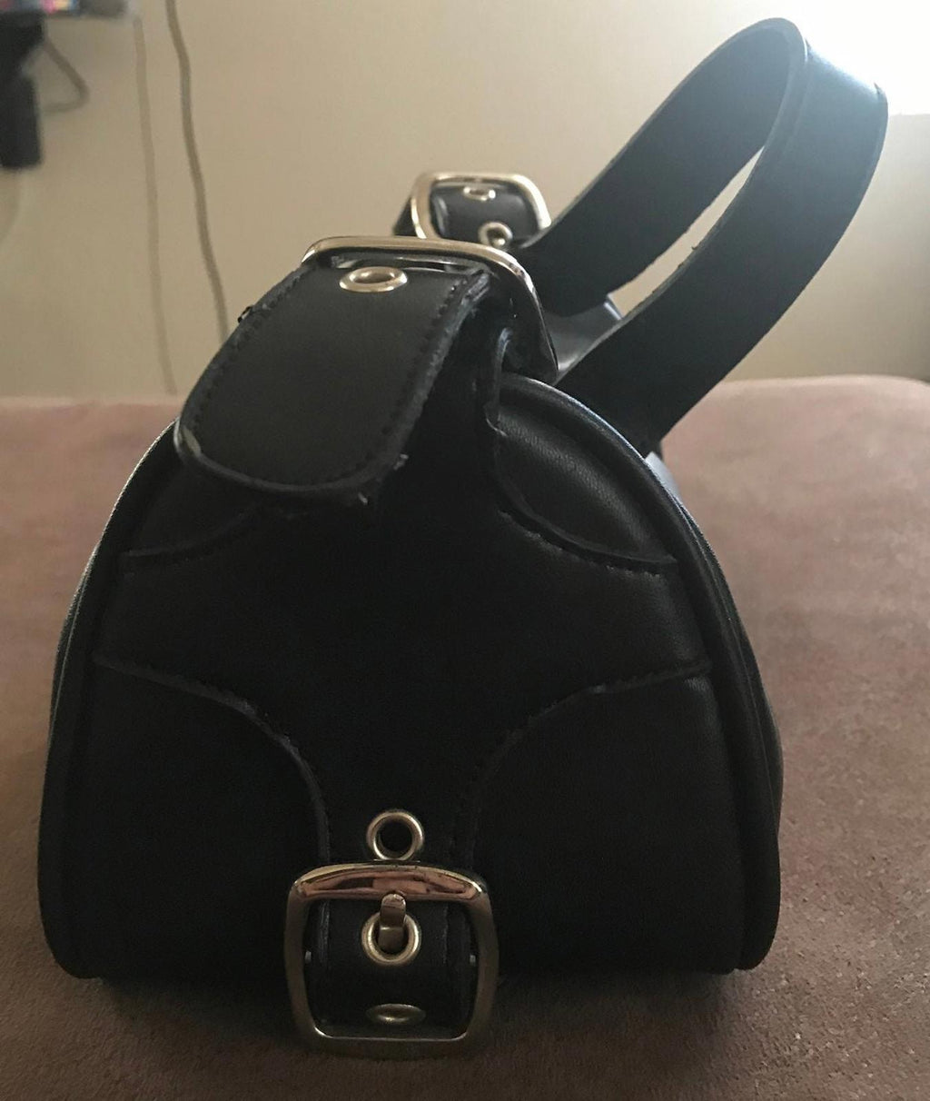 Black leather top-handle purse with front buckle clasp and stitched curved panels
