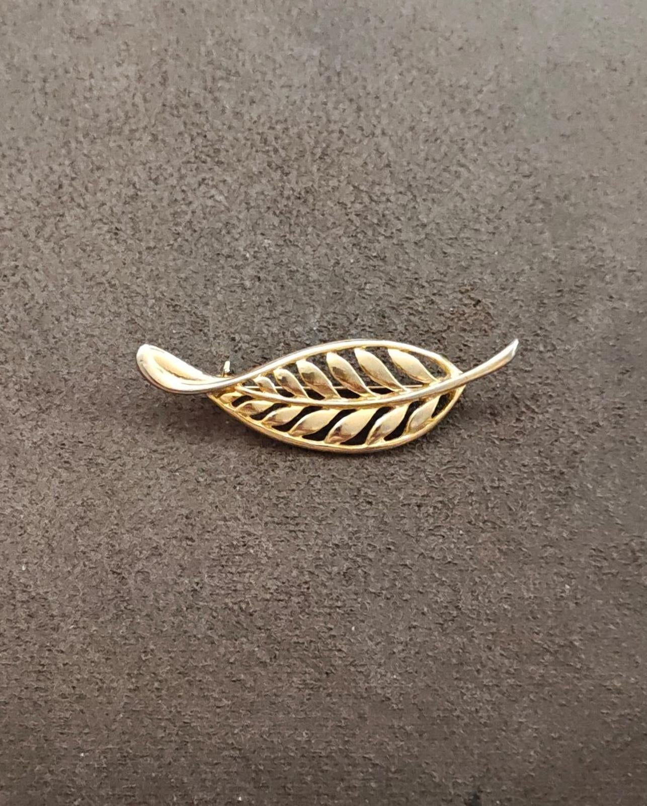 Gold tone leaf brooch with openwork filigree feather motif, pin visible