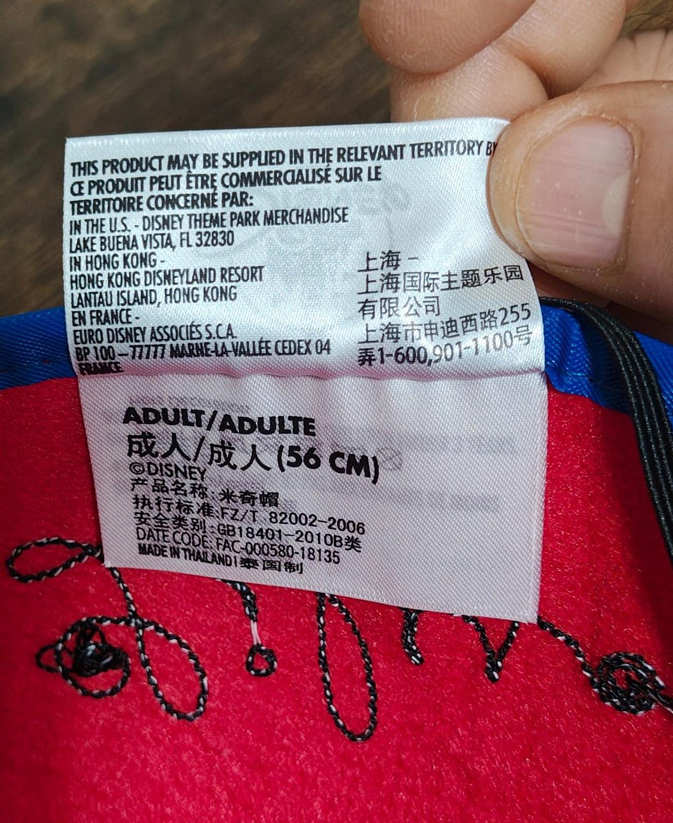 Inside tag on red felt ear hat with size and origin details for adults