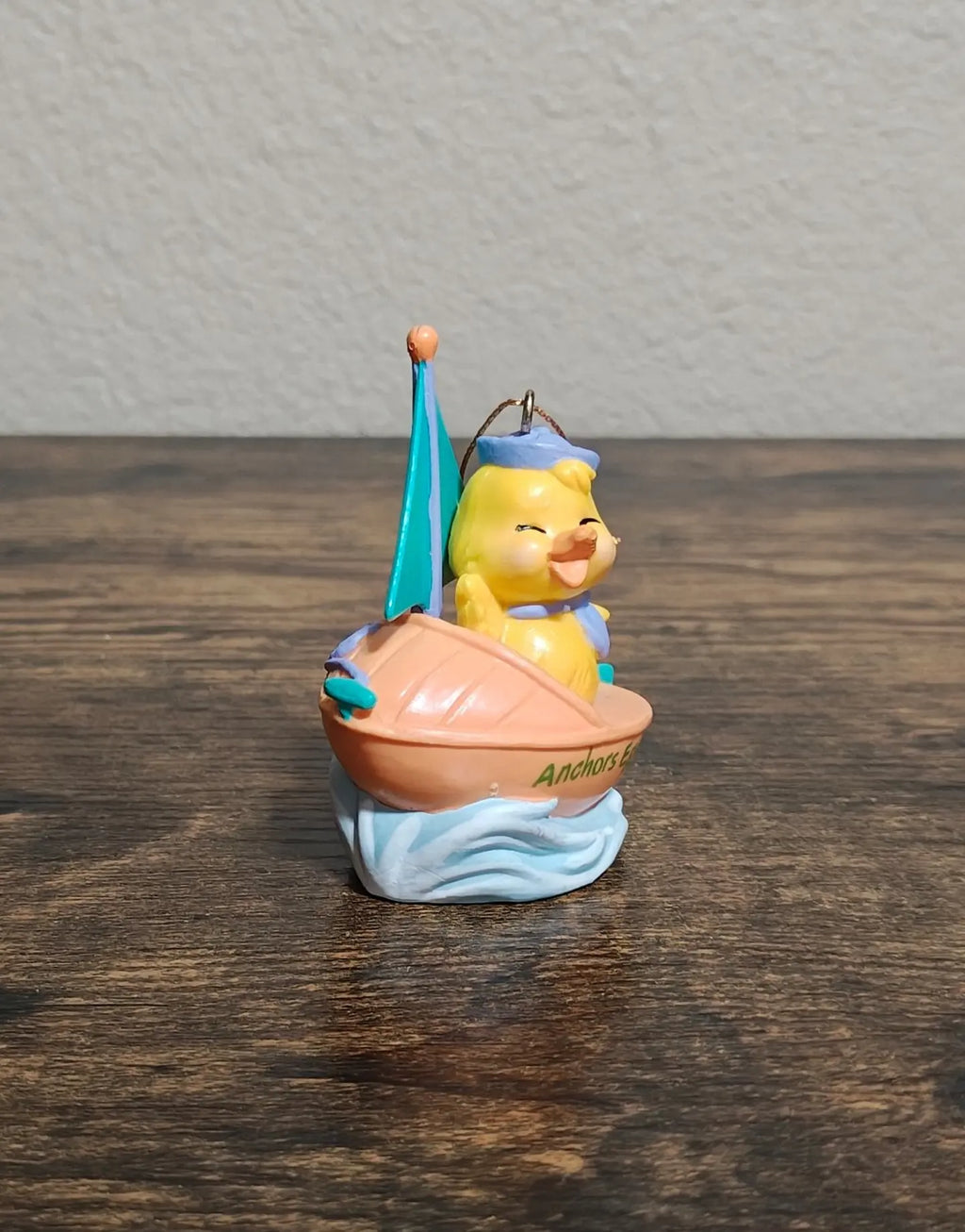 Avon ceramic Easter sailboat ornament with yellow sailor and pink boat, teal sail