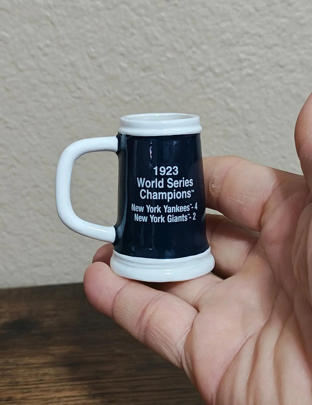 Handheld dark blue decorative miniature mug with white handle and '1923 World Series Champions' text.