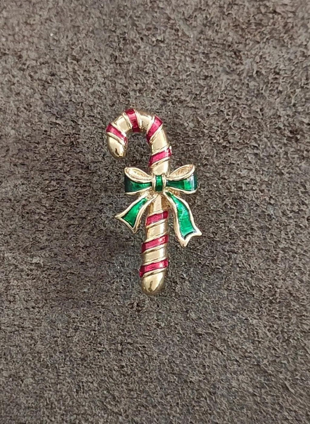 Candy cane enamel pin, red-striped cane with green bow and gold-tone accents