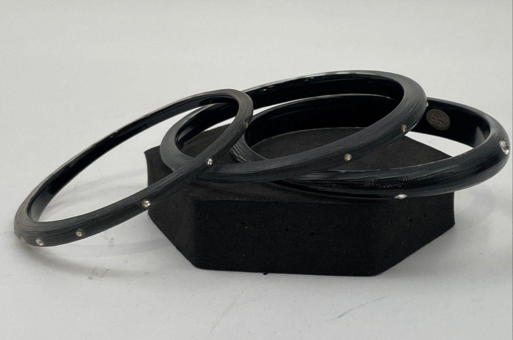 Black lucite bangles stacked with silver crystal accents on open ends