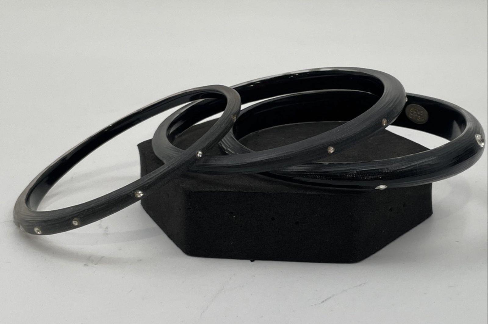 Black lucite bangles stacked with silver crystal accents on open ends