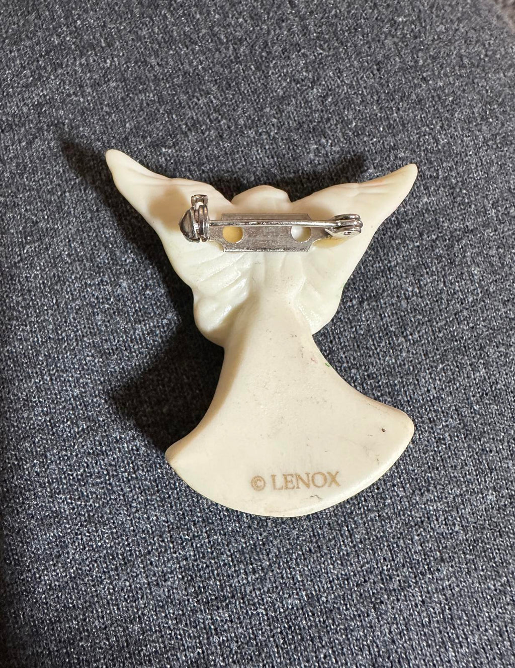 Ivory porcelain angel brooch back showing metal pin and gold-toned clasp
