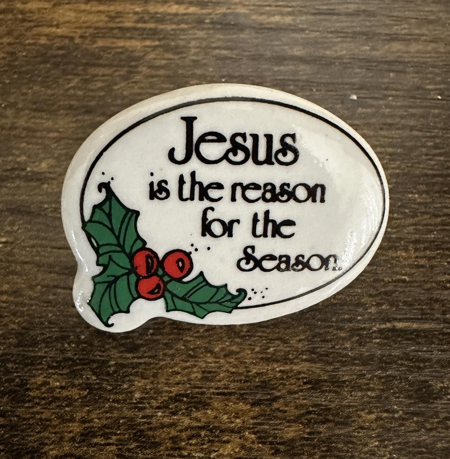 Jesus holiday lapel pin face with black lettering and green holly with red berries