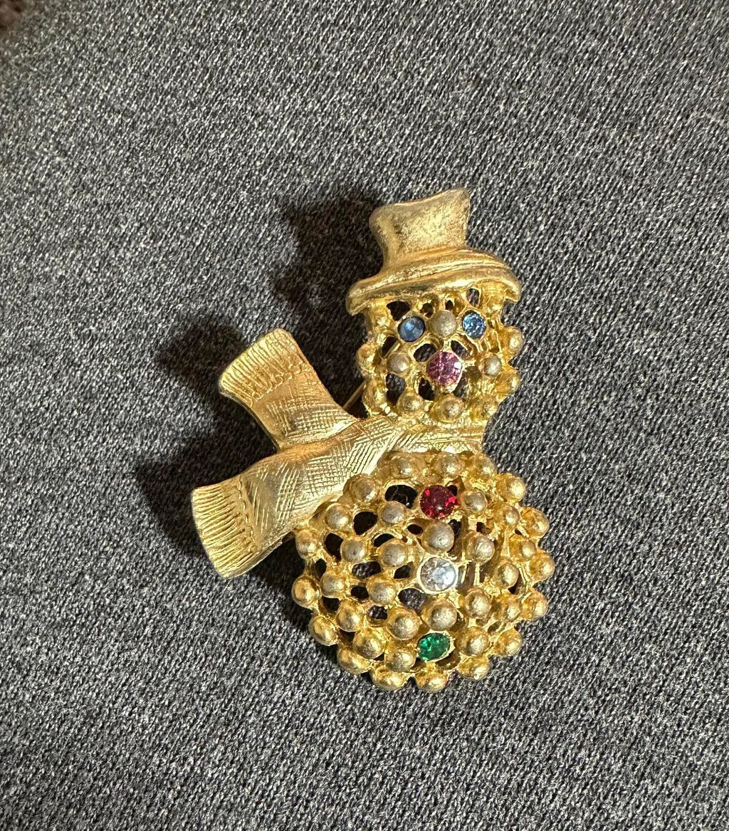 Gold-tone snowman brooch with colorful rhinestone hat and studded body