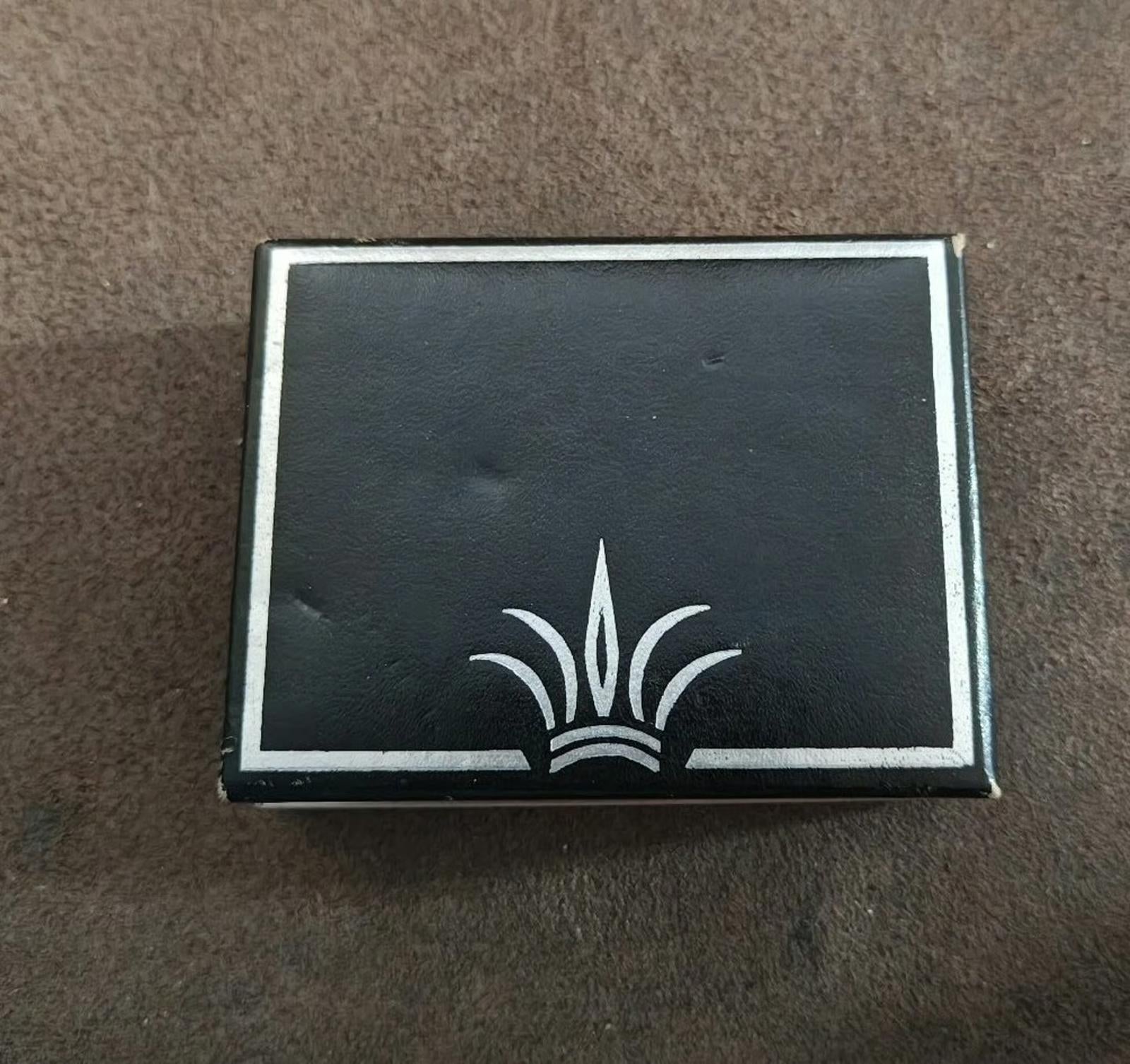 Black gift box with silver brand logo emblem, closed