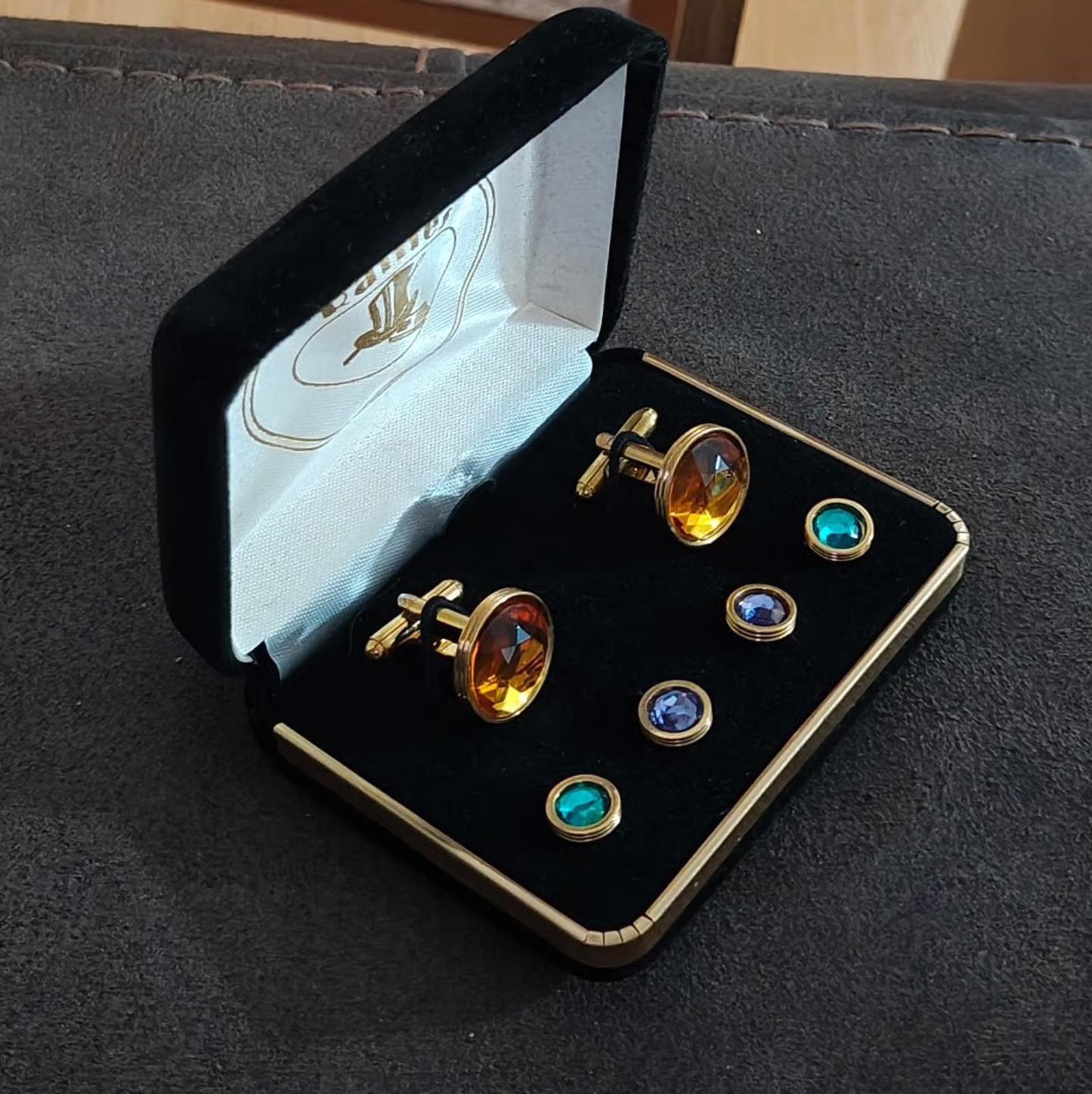 Gold-tone cufflinks and shirt studs set with amber and blue/teal stones in open case