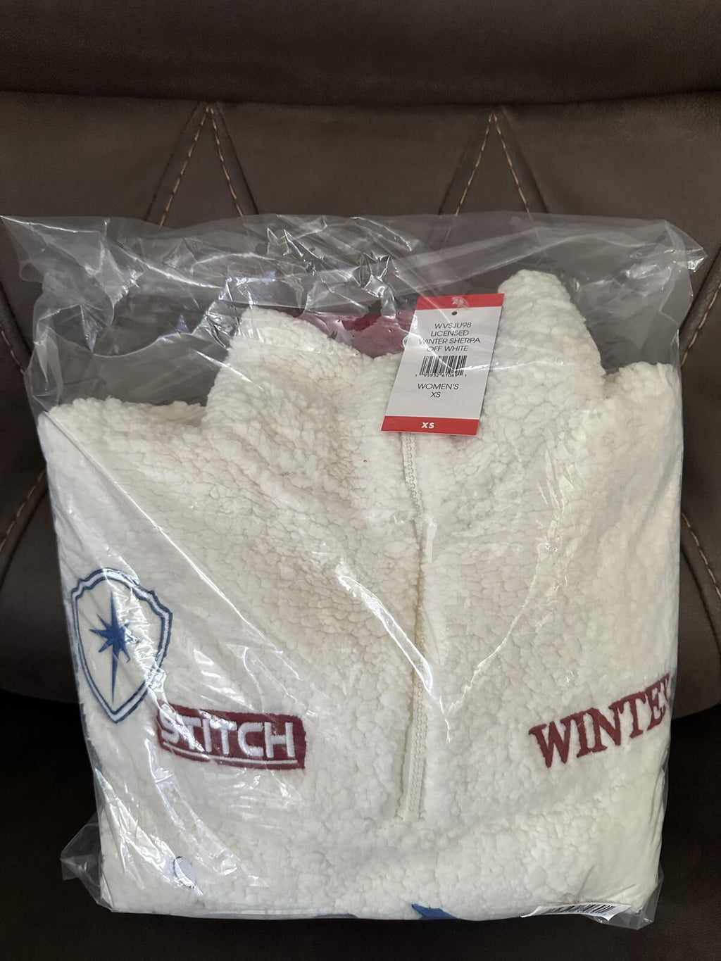 White sherpa pullover with red collar and Stitch front graphic, packaged in bag