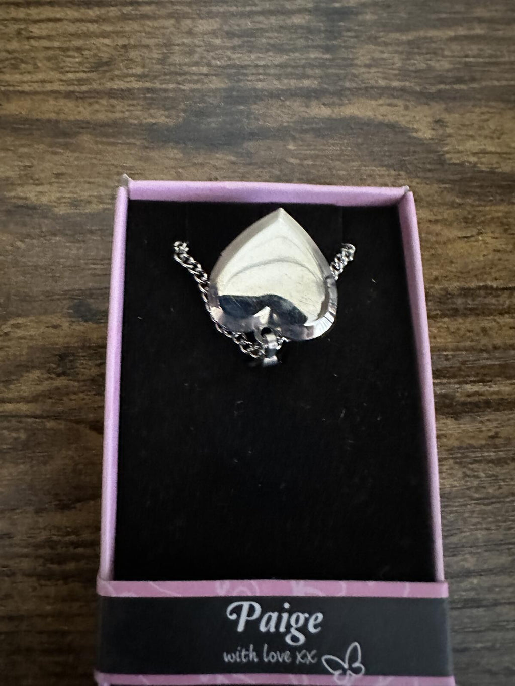 Silver tone heart locket necklace with “Paige” medallion and chain, in box.