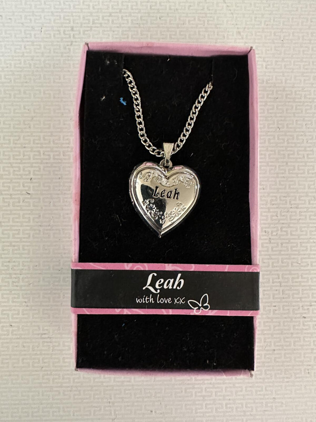 Silver-tone heart locket necklace in pink gift box, engraved Leah heart pendant on chain.
