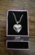 Silver-tone heart locket necklace with chain, engraved 'Leah' heart pendant.