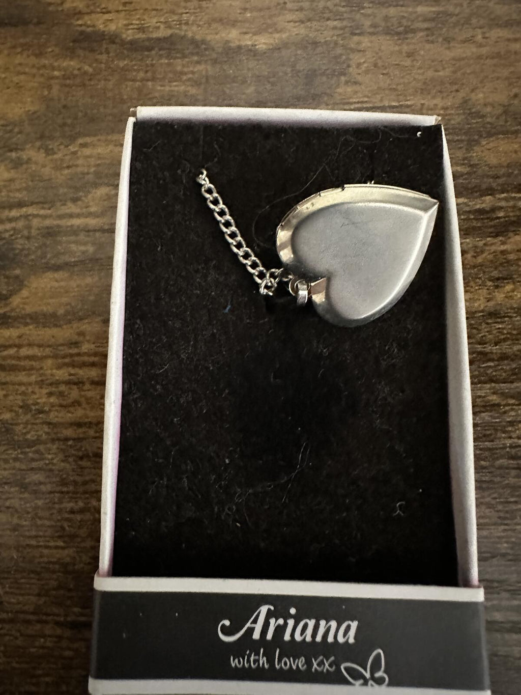 Silver tone heart locket necklace showing the side view of the pendant