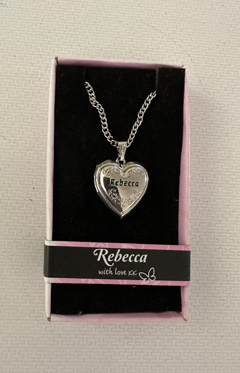 Silver-tone heart locket necklace with engraved “Rebecca” pendant on chain.