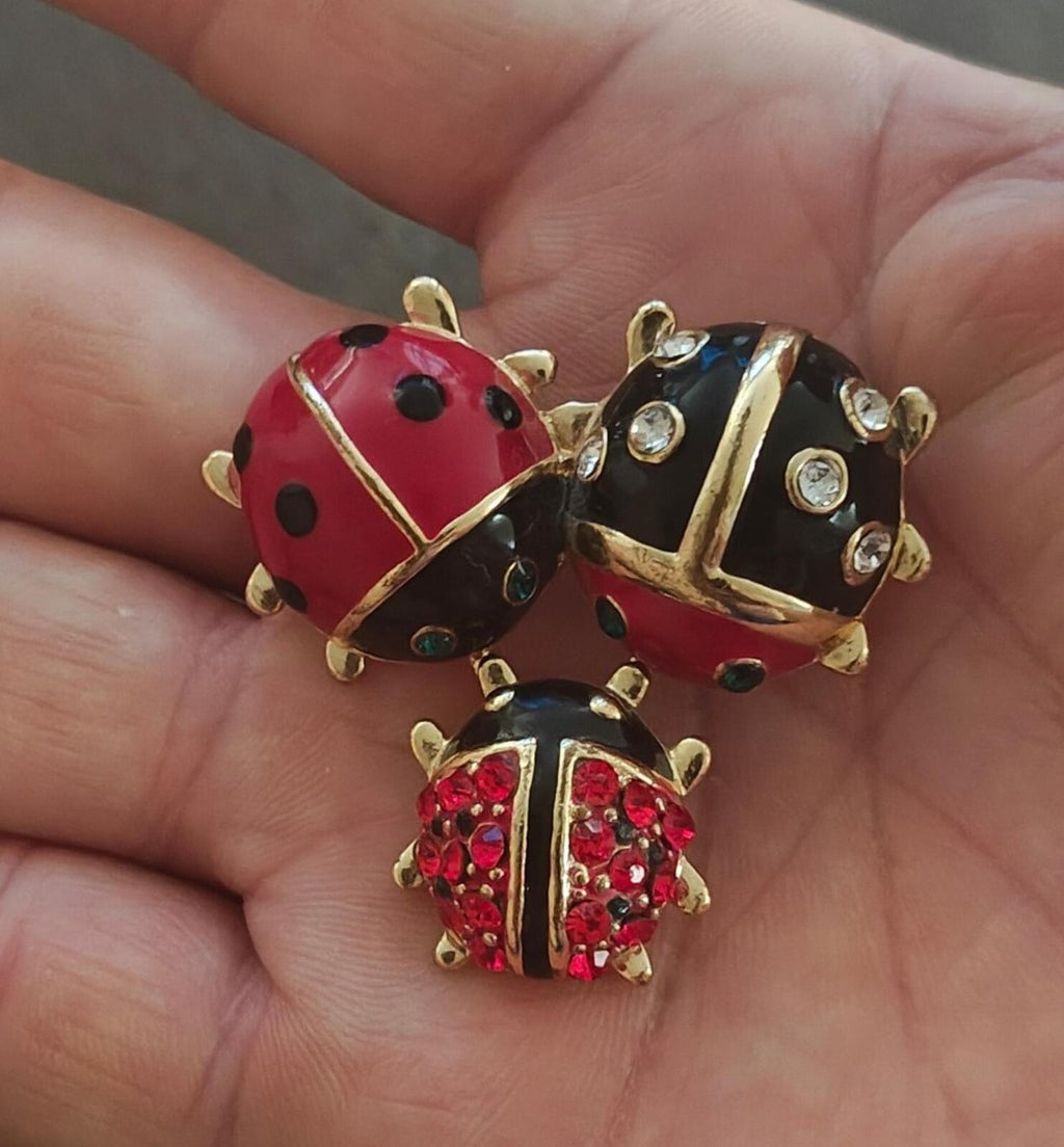 Red and black enamel ladybug trio brooch with clear rhinestone accents and gold-tone trim