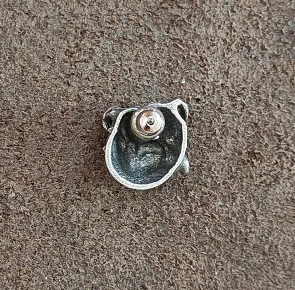 Back of a silver-tone bulldog head pin showing a round clasp