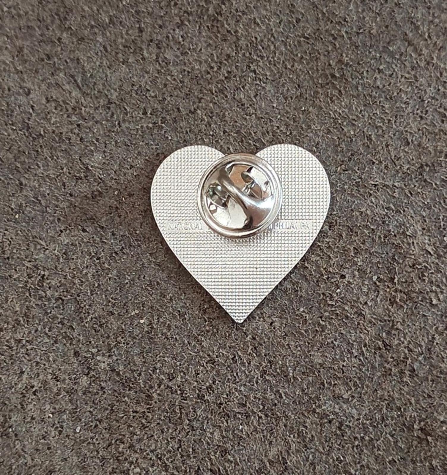 Heart-shaped silver-tone pin back with round clutch fastener
