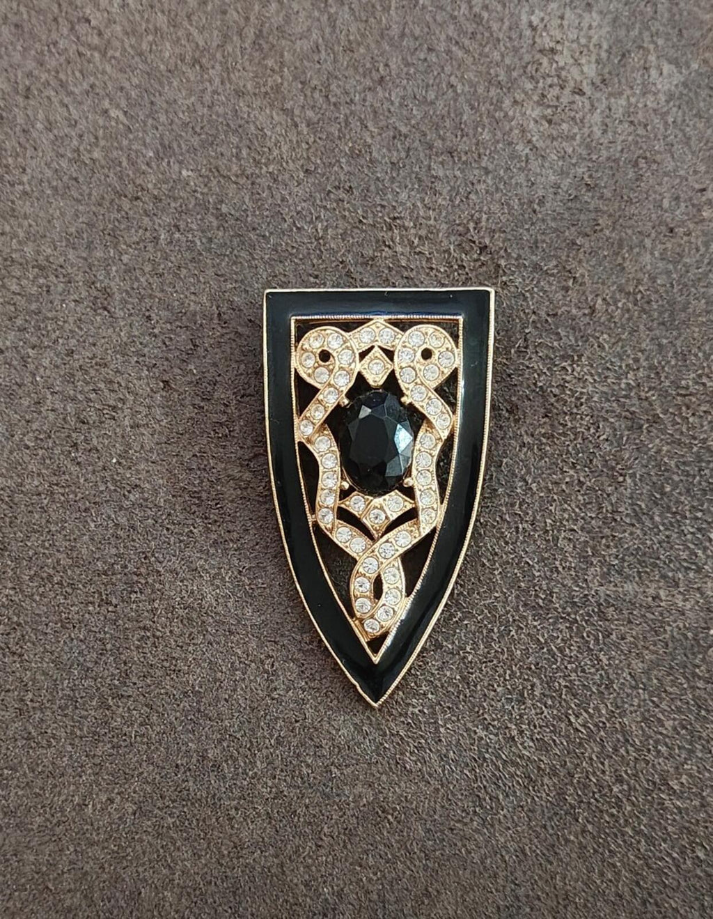 Gold tone Art Deco shield brooch with dark center stone and clear rhinestones, black enamel