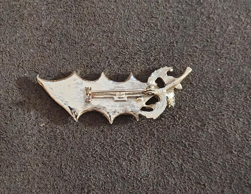 Back side of holly Christmas enamel brooch pin with clasp and safety catch.