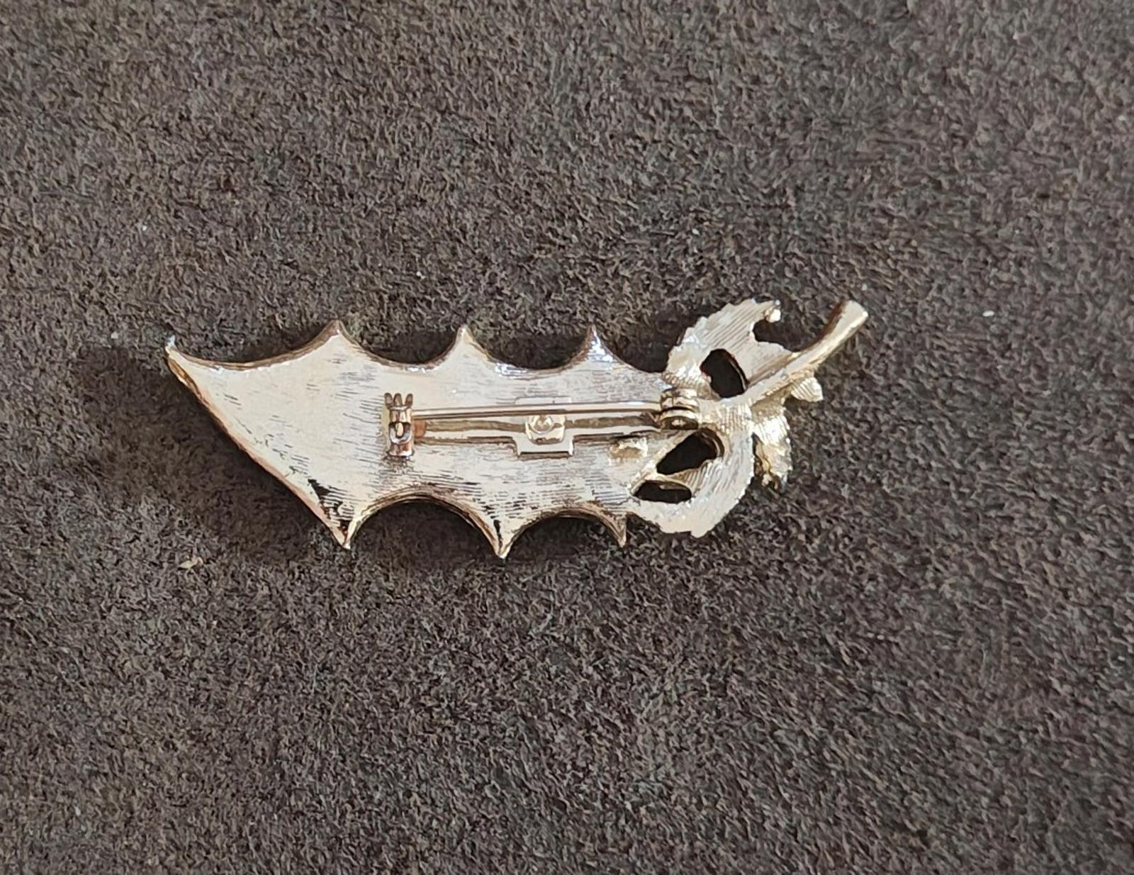 Back side of holly Christmas enamel brooch pin with clasp and safety catch.