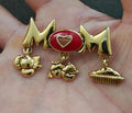 Gold-tone MOM brooch pin with red heart enamel center and three dangling charms