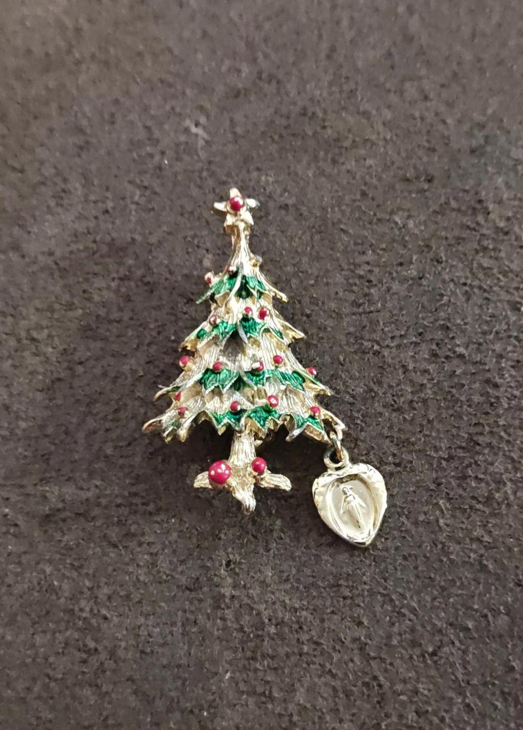 Gold-tone Christmas tree brooch with green enamel layers, red accents, and heart medal