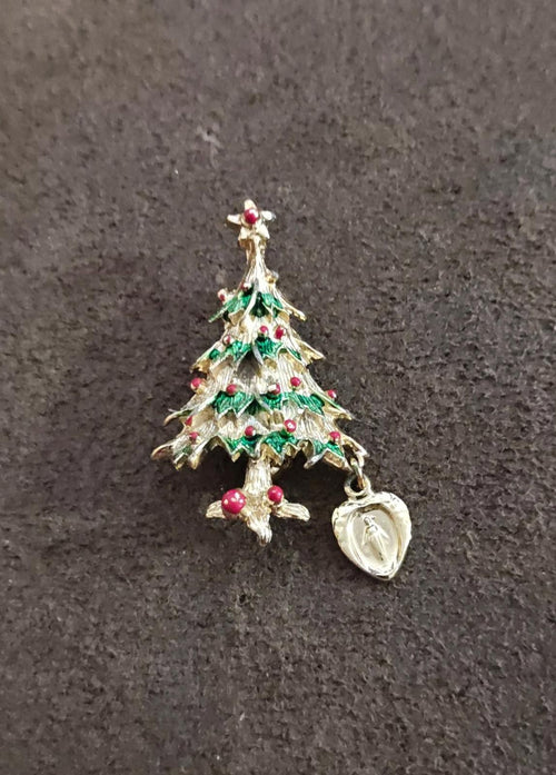 Gold-tone Christmas tree brooch with green enamel layers, red accents, and heart medal