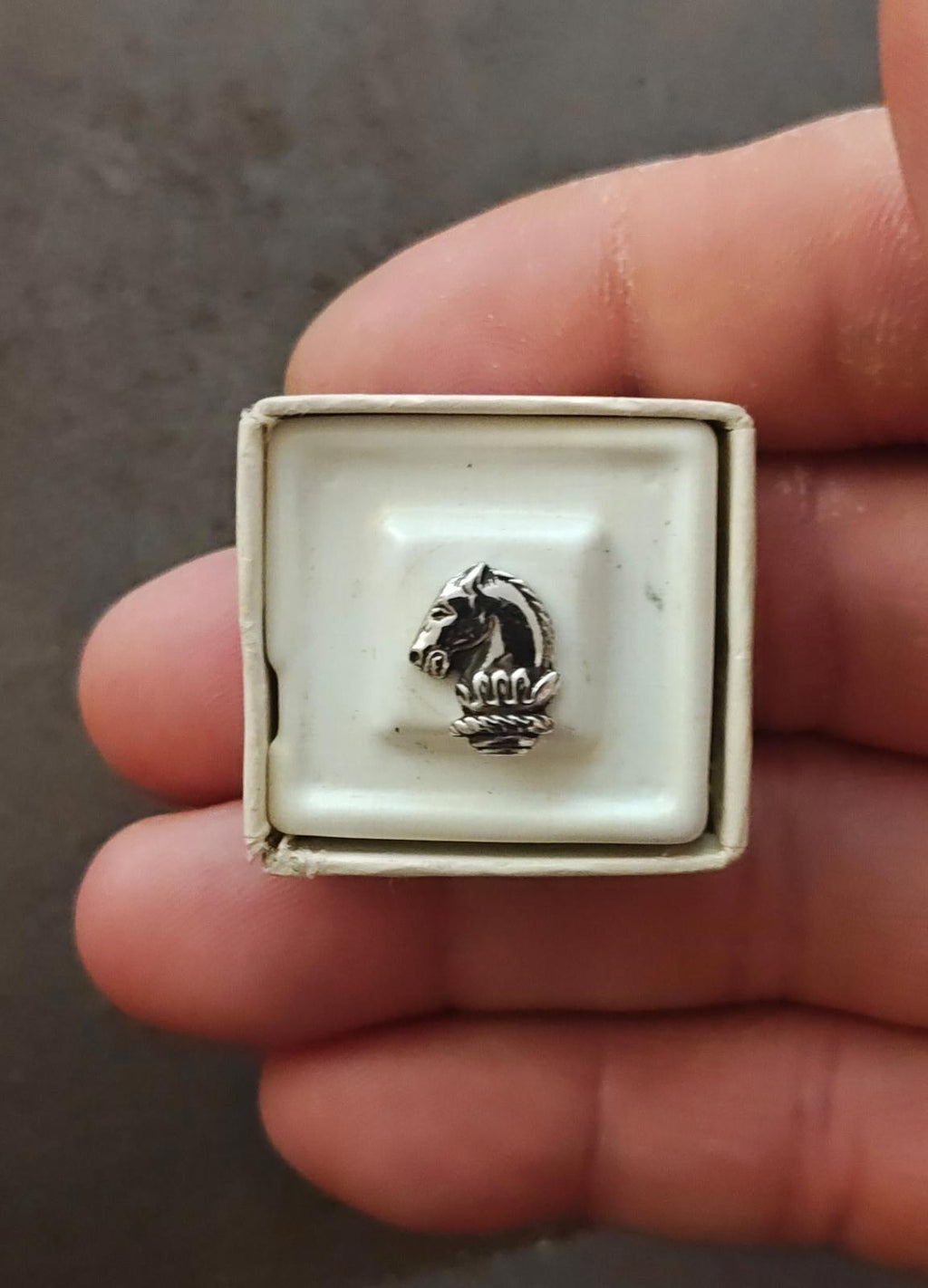 Silver-tone horse head tie tack pin showing curled mane and stacked base