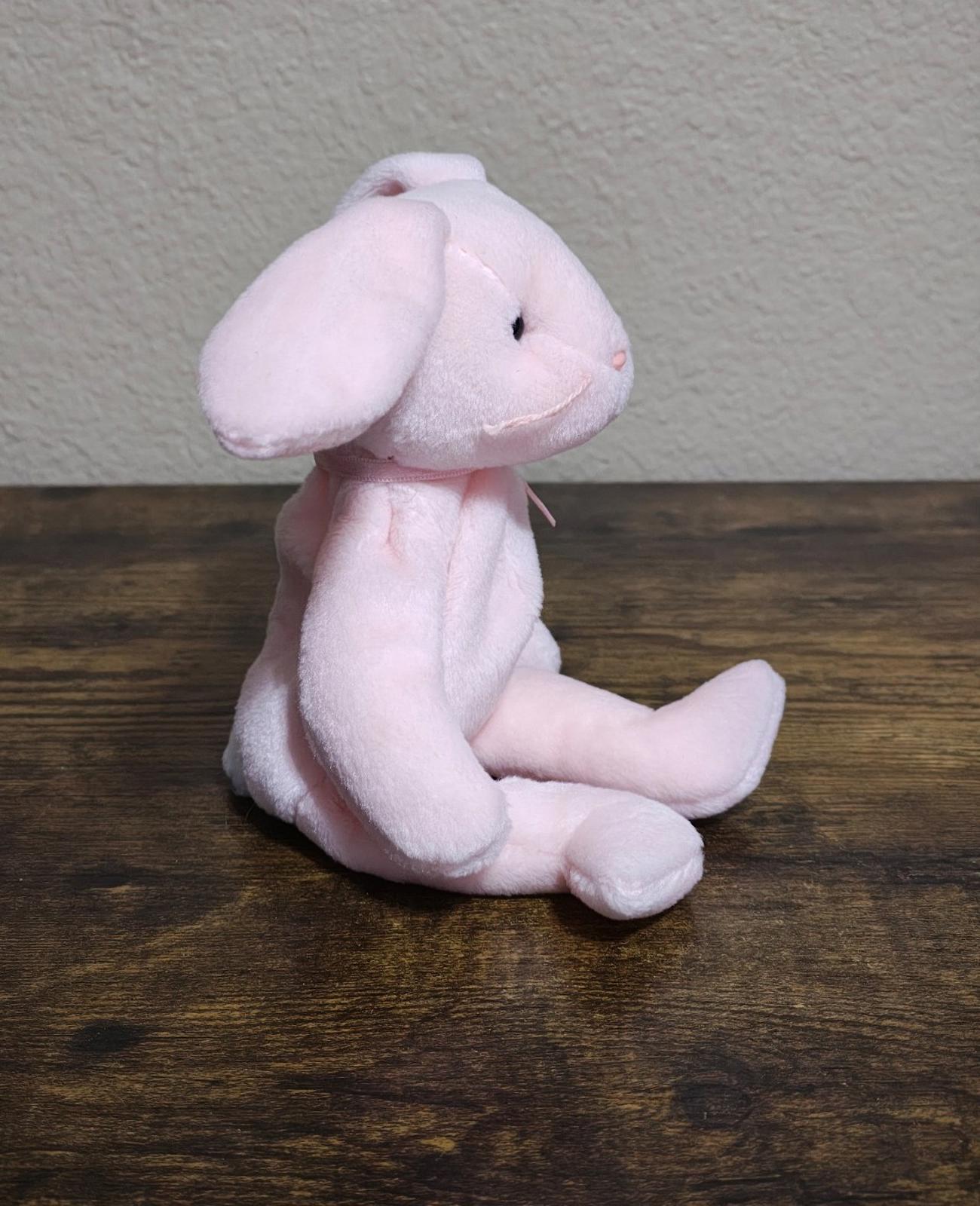 Pink plush bunny beanbag profile view with long ears and stitched eyes