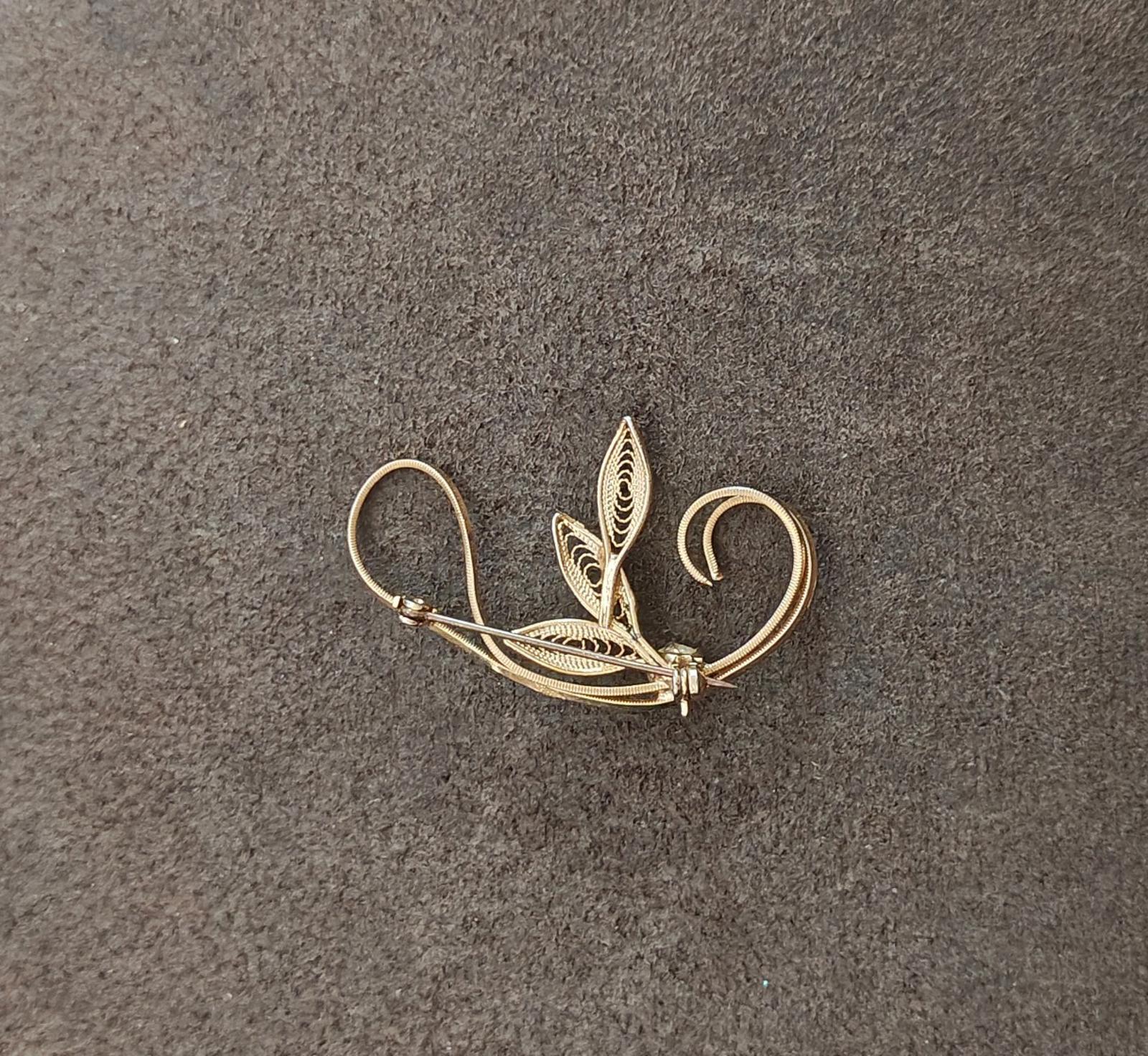 Gold tone leaf filigree brooch with faux pearl bead, pin back loops and leaf center