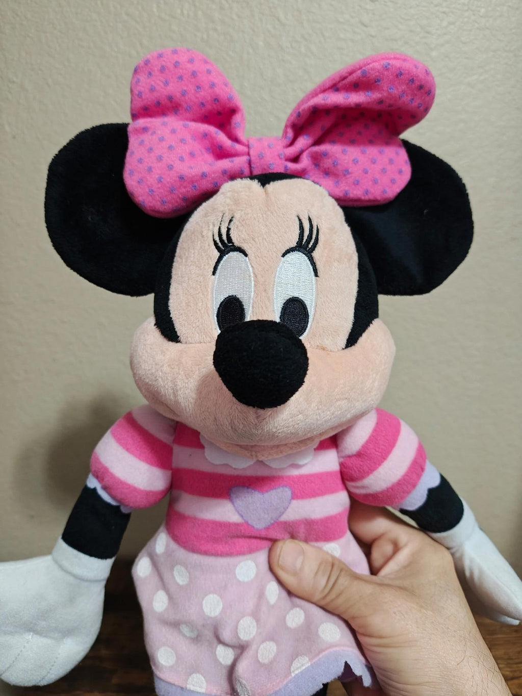 Pink Minnie Mouse plush doll facing forward with pink polka-dot bow and striped top