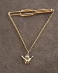 Gold-tone bowling-themed tie bar with chain and pin-shaped charm pendant.