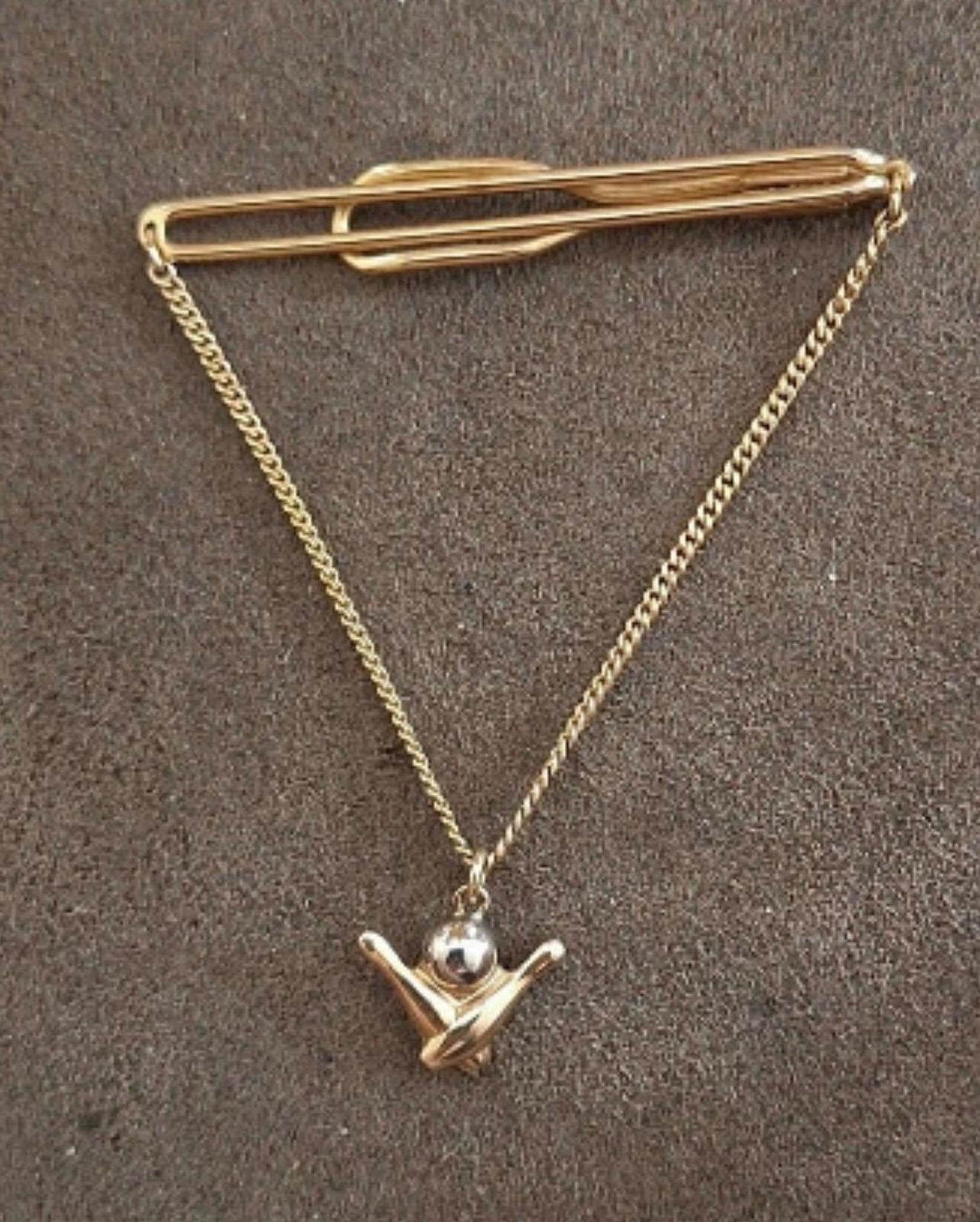 Gold-tone bowling-themed tie bar with chain and pin-shaped charm pendant.