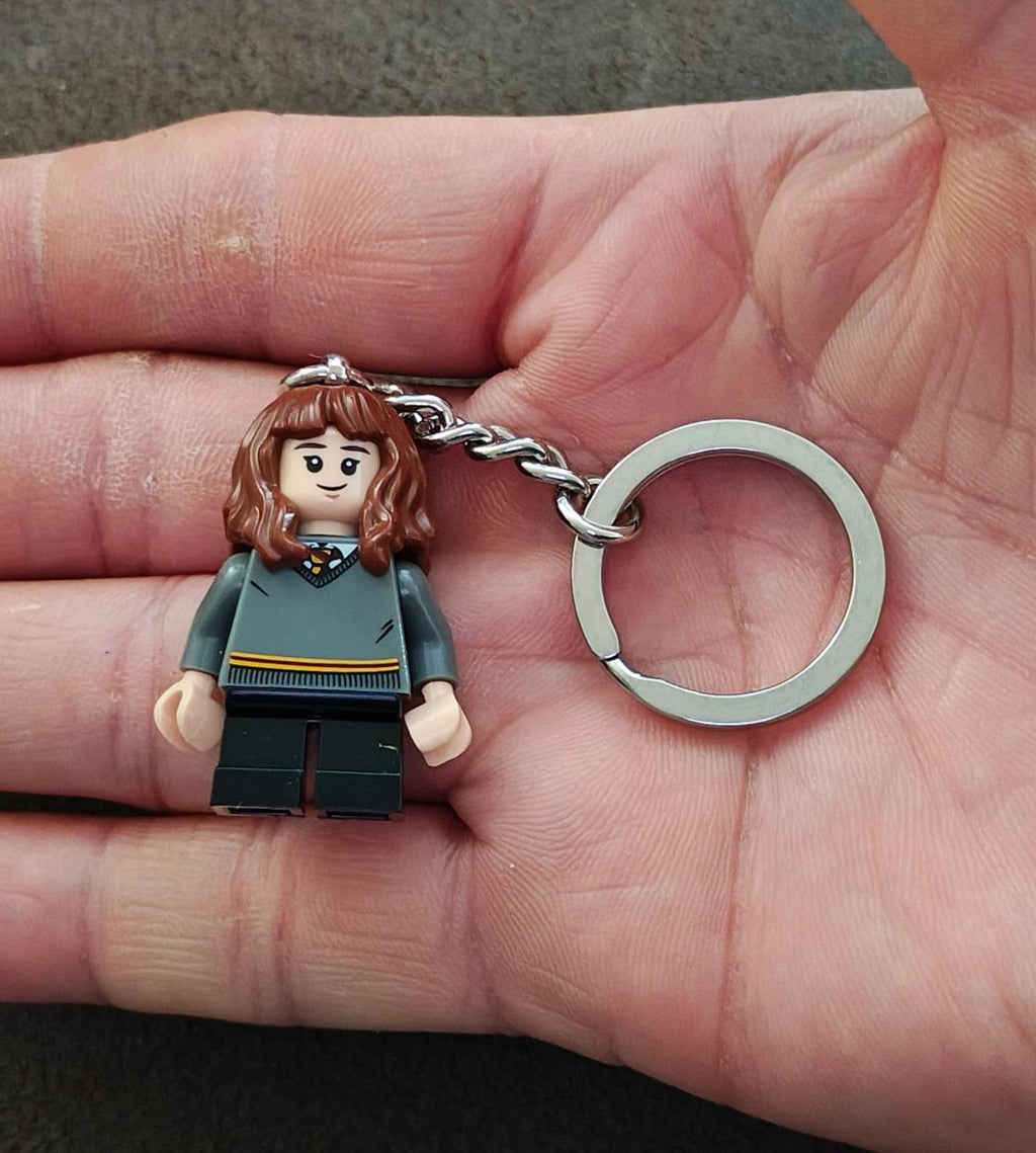 LEGO-style minifigure keychain with brunette hair, teal sweater, dark pants, silver chain ring