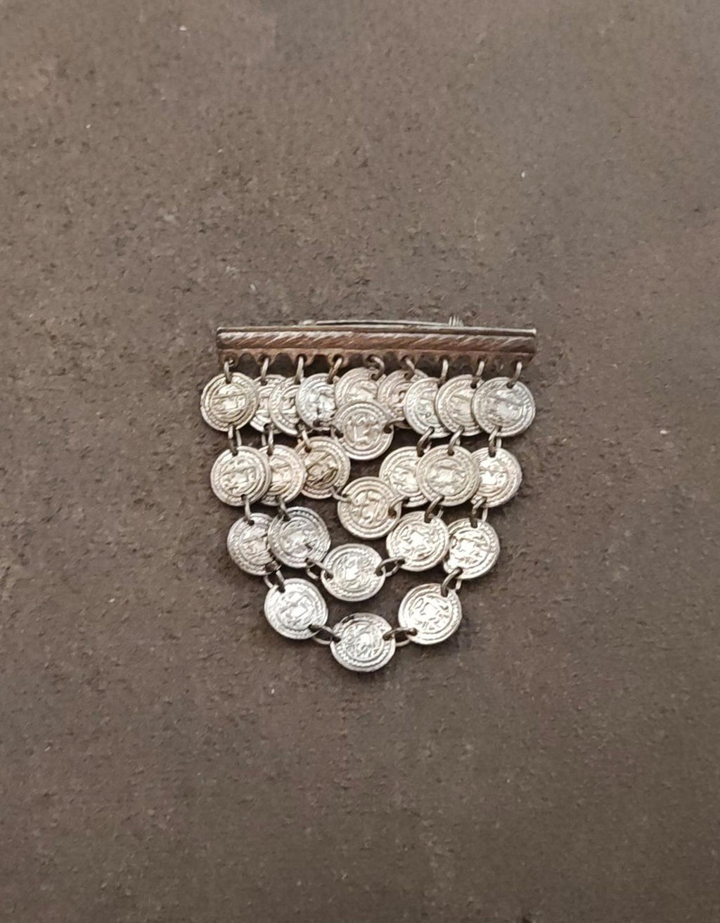 Silver-tone coin dangle brooch showing round coin charms and rectangular top bar