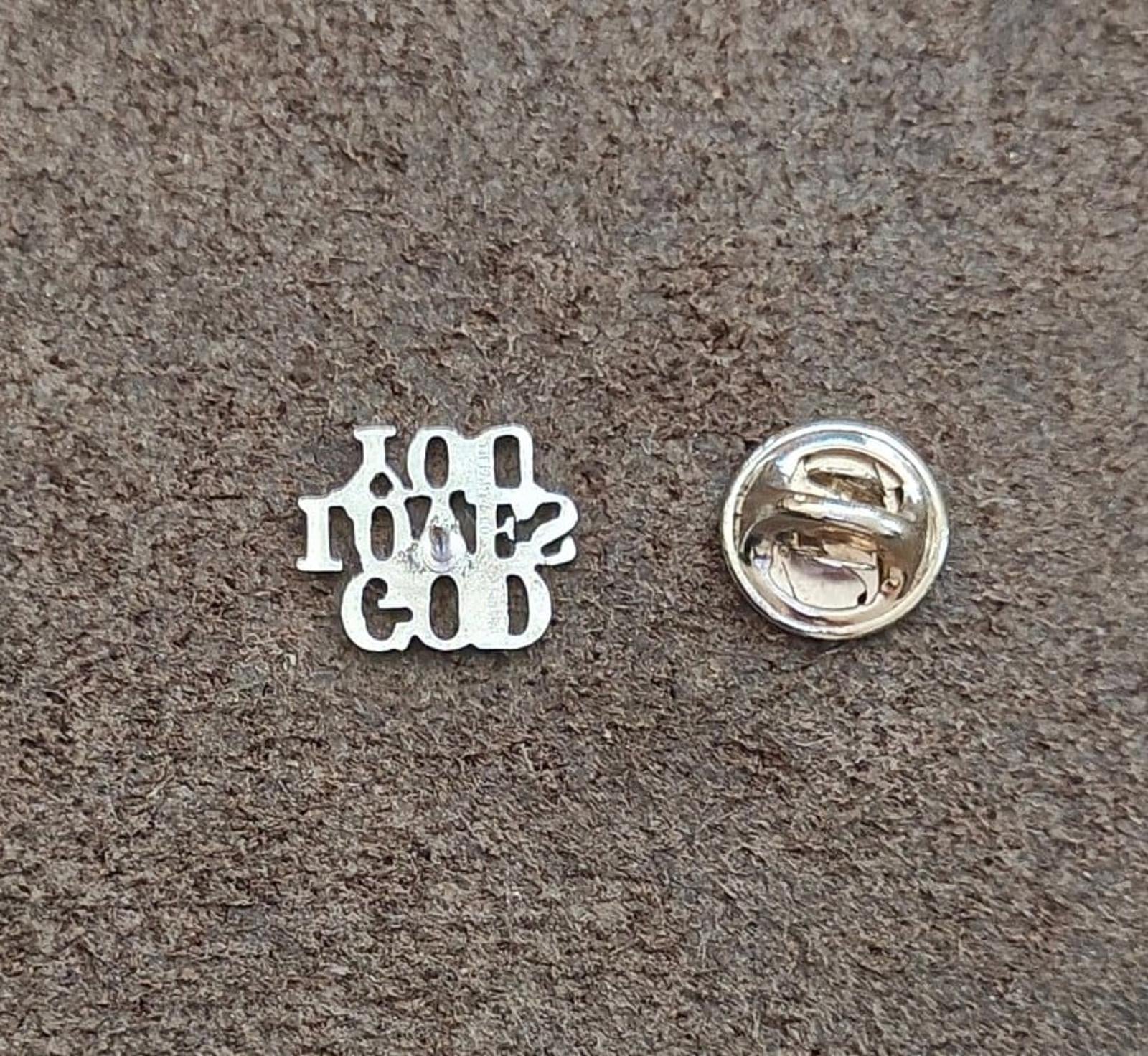 Sterling silver pin back showing safety pin clasp and maker details