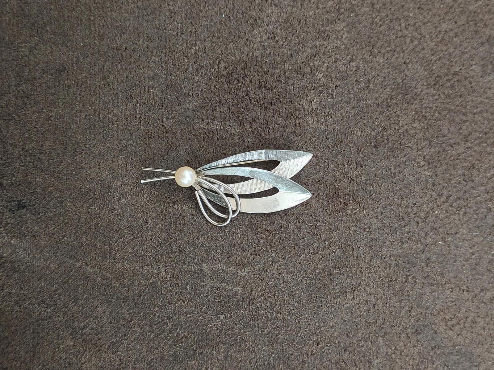 Sterling silver leaf-shaped brooch with cultured pearl center and curved wire details