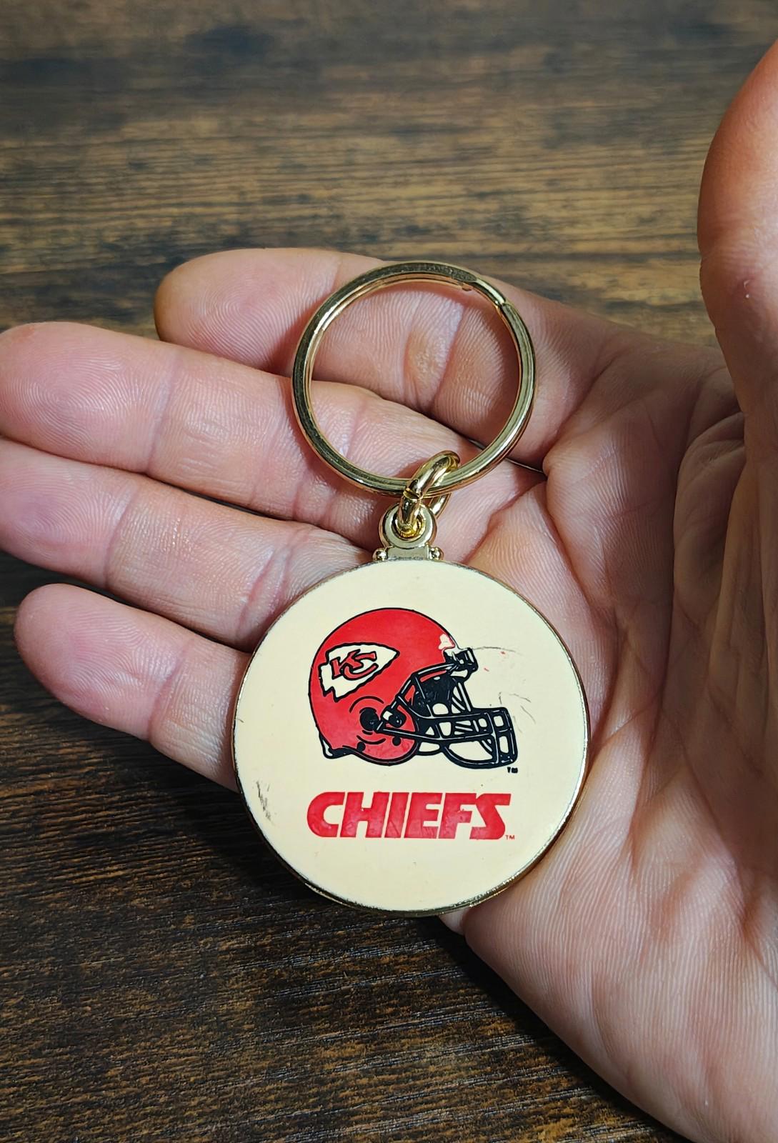 Kansas City Chiefs helmet keychain held in hand, gold ring with round enamel logo